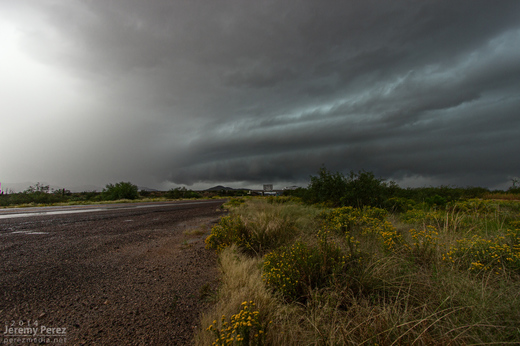 A striated shelf cloud approaches the intersection of Highway 93 and 71. The rain free base on this supercell was obscured by surrounding precipitation. View is to the southwest. 1:05 PM / 2005Z